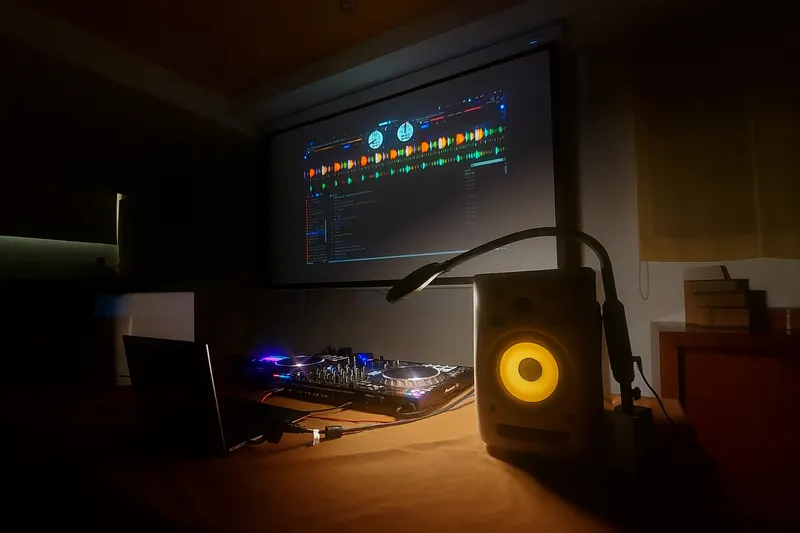 Controladora Pioneer y monitor con el software de DJ proyectado en la pantalla