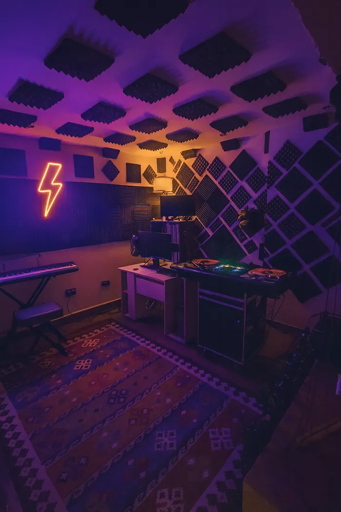 Estudio insonorizado de Studio Music Lab en Antequera, con neón en forma de rayo y platos